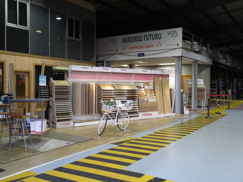 Tarima flotante de madera clara en almacen de Maderas Ocampo con escritorio minimalista y luz natural.