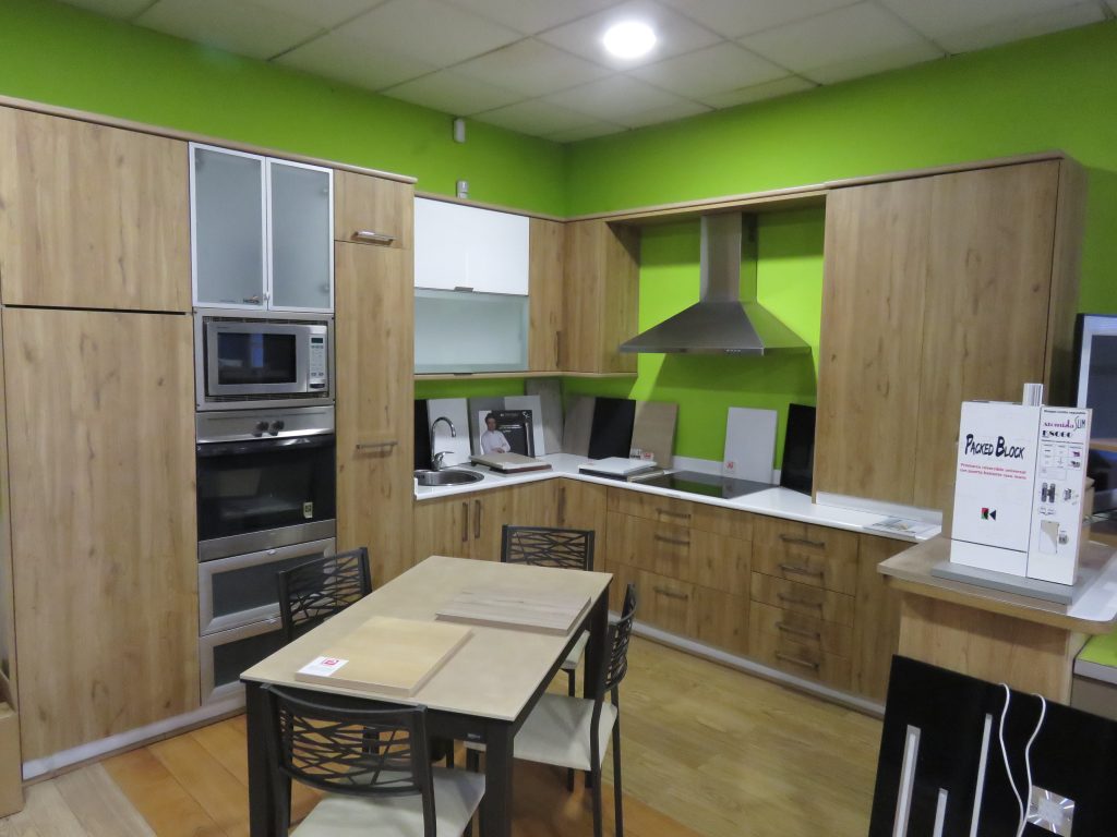 Cocina completa con isla central y puertas de madera, diseño moderno y funcional.